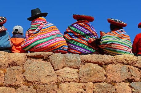 Quechua ladies and a young boy chatting on an ancient Inca wall